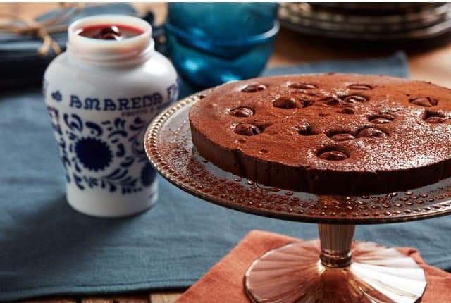 Cherries in a pot with a chocolate cake